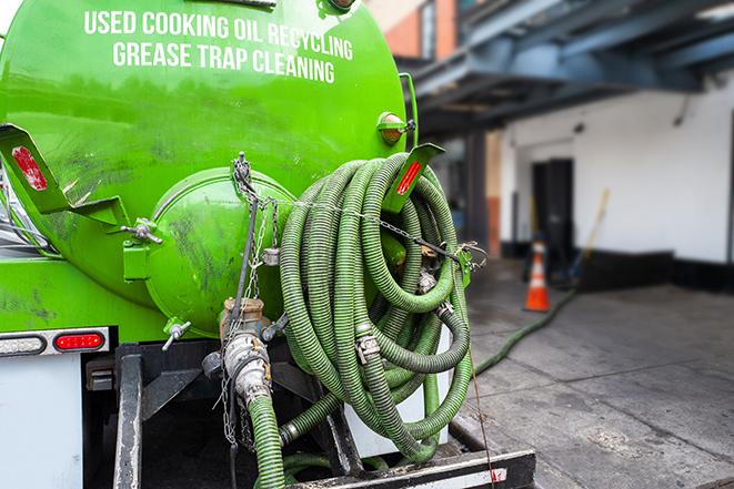 a vacuum truck pumping out a large underground grease trap in Bartlett